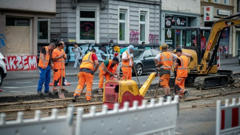 group of men in orange suit standing near building during daytime